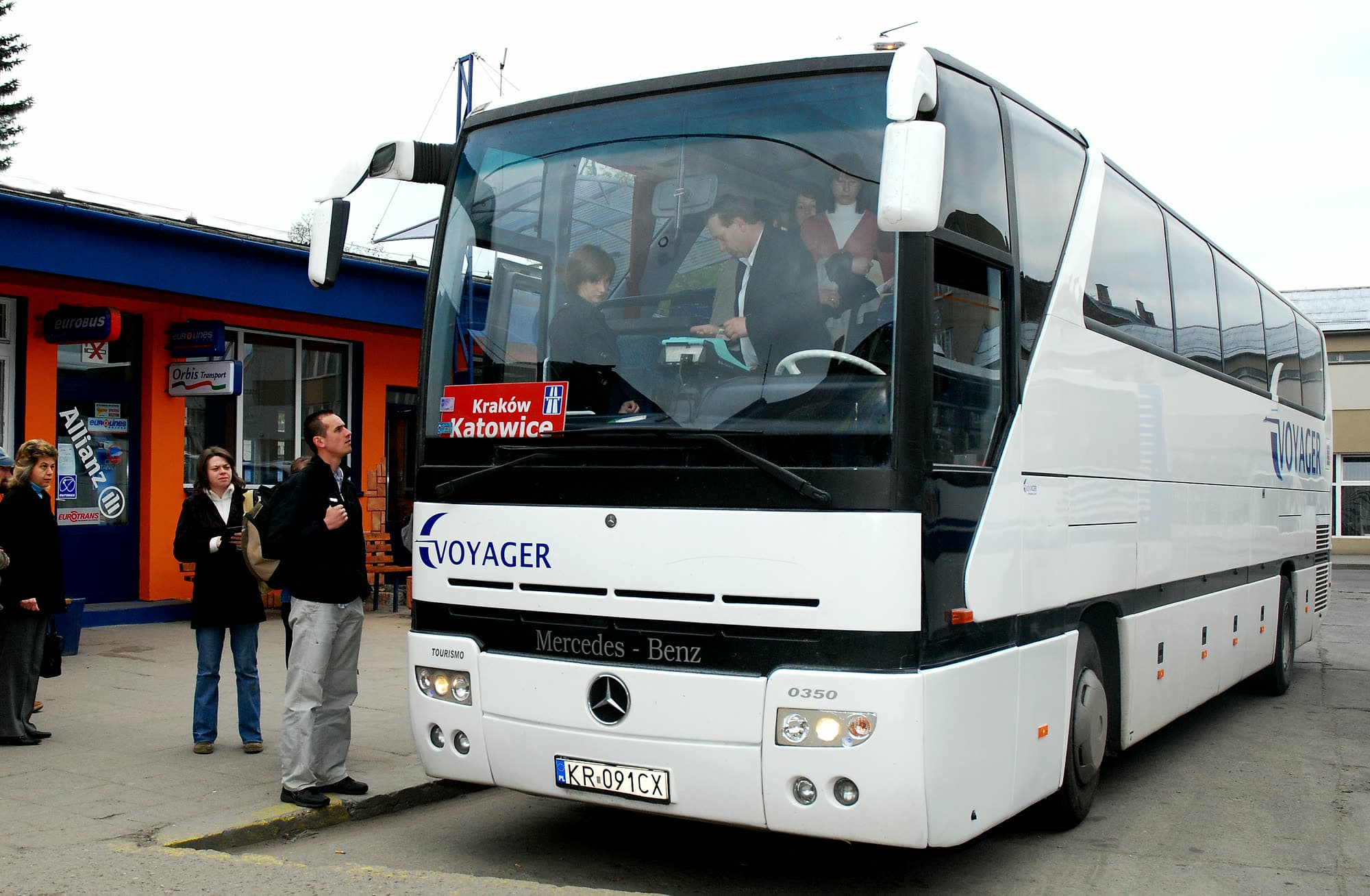 Pasażerowie na dworcu przy autokarze Voyagera